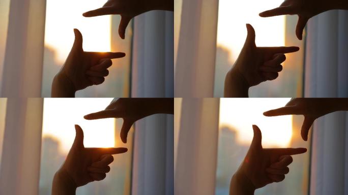 用指框相机观看日落的女性