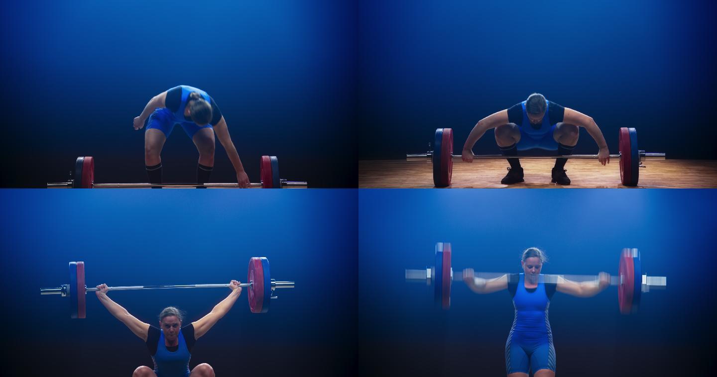 女子举重运动员在抓举比赛中举起杠铃