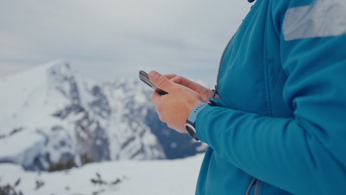 在雪山上使用手机的男子