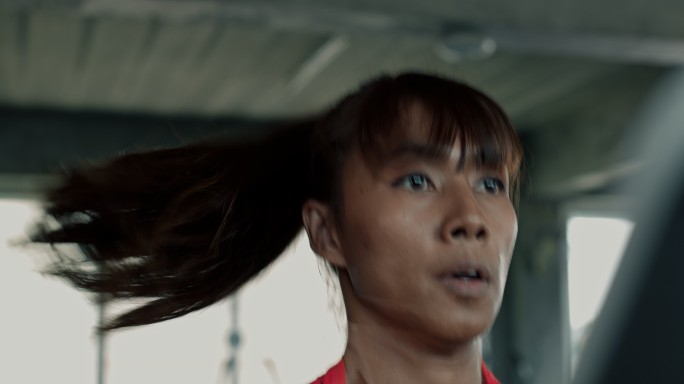 在跑步机上快速奔跑的女子的手持式照片。