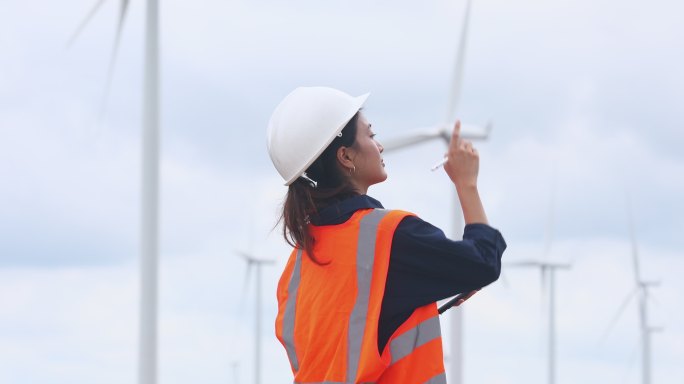 女工程师使用平板电脑在风力发电场现场工作