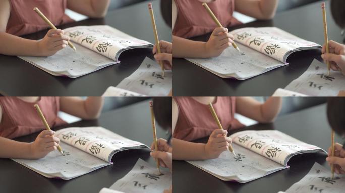 亚洲华人兄弟姐妹正在家里练习中国书法