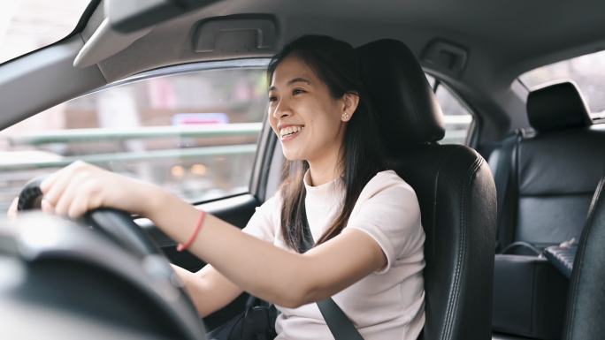 亚洲女性开车上班时在车内使用手机无线蓝牙