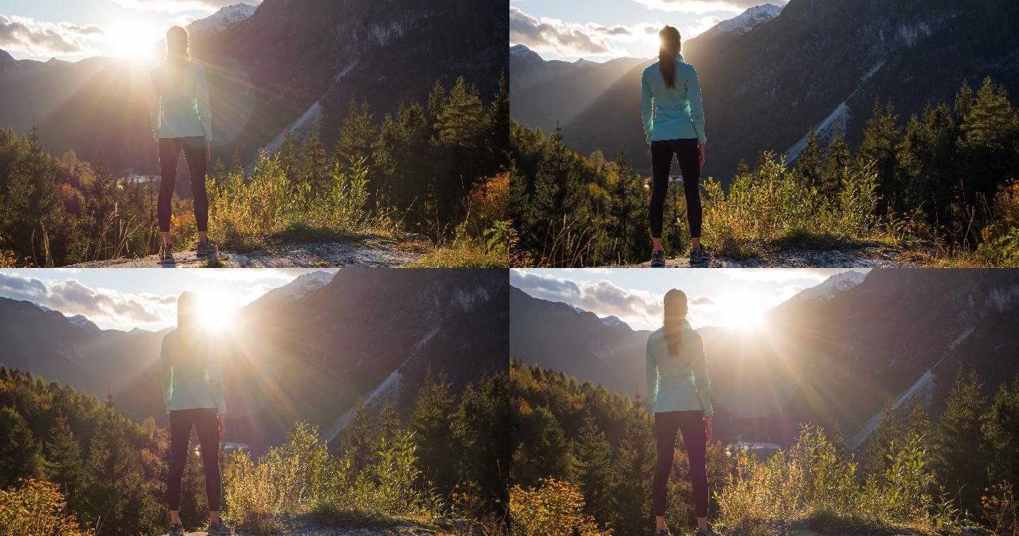 年轻的女性徒步旅行者在日落时从悬崖边欣赏山谷湖的壮丽景色