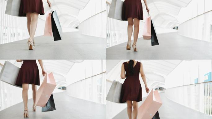 自信的女人在购物中心拎着购物袋走路