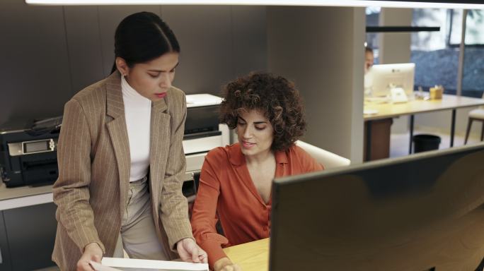 女性设计同事一起在计算机显示器上工作