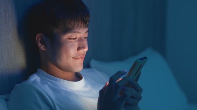 男人在晚上使用智能手机