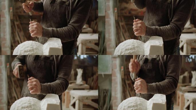男雕塑家的斯洛·莫（SLO MO）手在雕刻雕塑