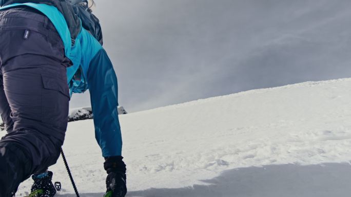 拿着冰斧爬雪山的登山者