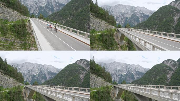 由五名公路自行车手组成的空中骑行队，他们骑在高山上的一座桥上