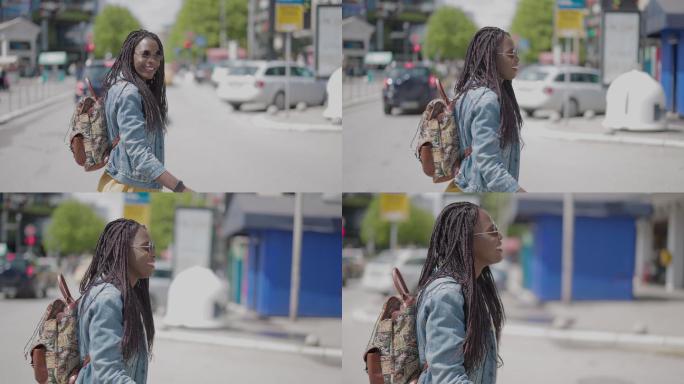 年轻的非洲女子背着背包在人行横道上横穿街道