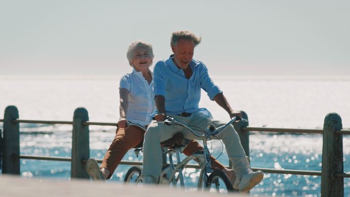 老年夫妇在长廊上骑双人自行车