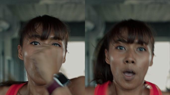 女性在跑步机上快速奔跑的垂直视频。
