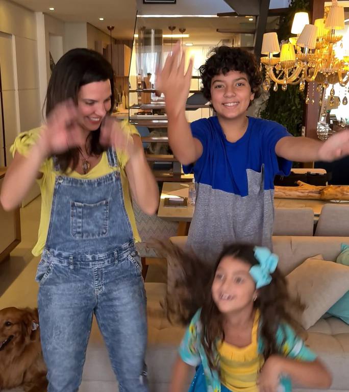 妈妈和孩子们在家里为社交媒体跳舞和拍摄——移动摄像机视角