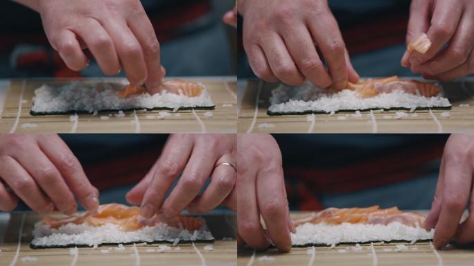 日本厨师在做寿司卷时把三文鱼放在米饭上