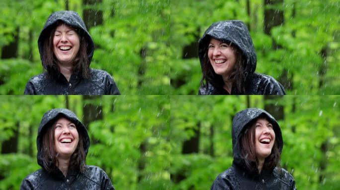 快乐的女人穿着雨衣在森林里徒步旅行