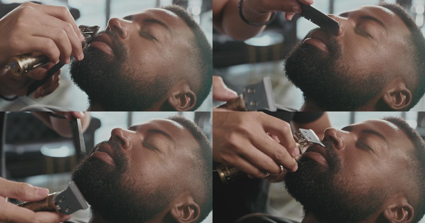 4k视频，一个英俊的年轻人坐在理发店，被理发师剃胡子