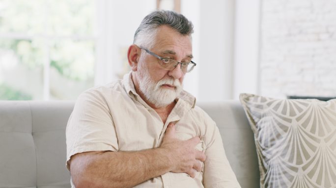 一名老年男子坐在家中时胸痛的4k视频片段