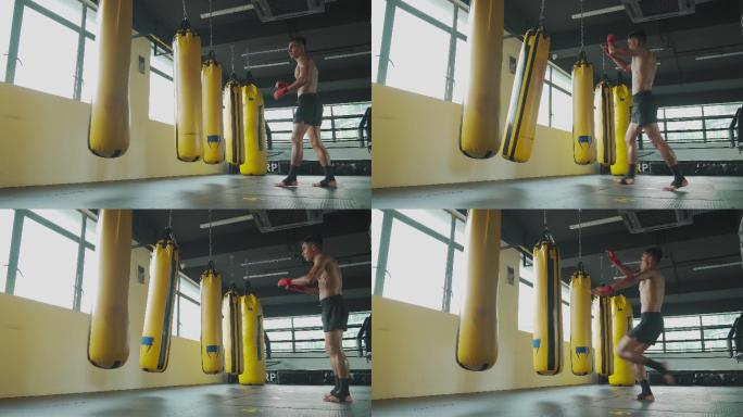 亚裔马来泰拳拳击手在健身房健身俱乐部的飞腿拳击袋
