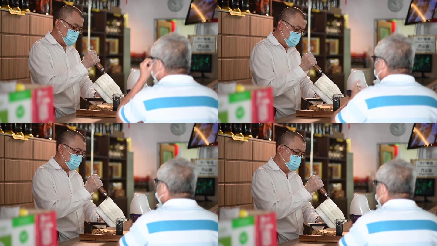 亚裔中国男药剂师在中药店为年长的病人切人参中药