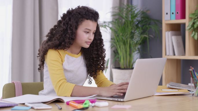 一个十几岁的女孩在做功课时使用笔记本电脑的4k视频片段