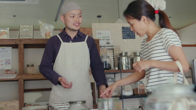 MS-日本员工在一家可持续零废物商店帮助客户称量产品