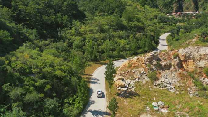 汽车行驶在公路路林间穿梭弯路山路村庄