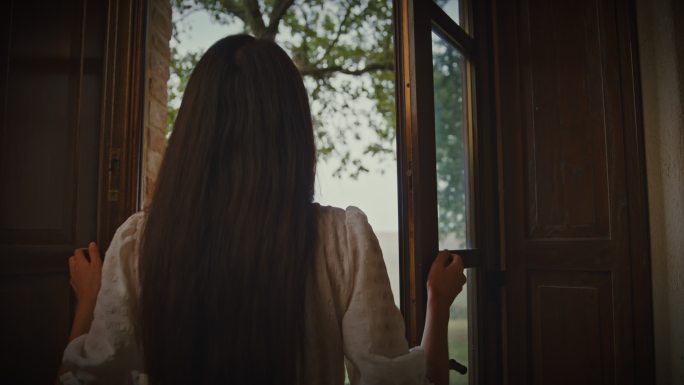 SLO MO Woman打开托斯卡纳度假别墅的窗户