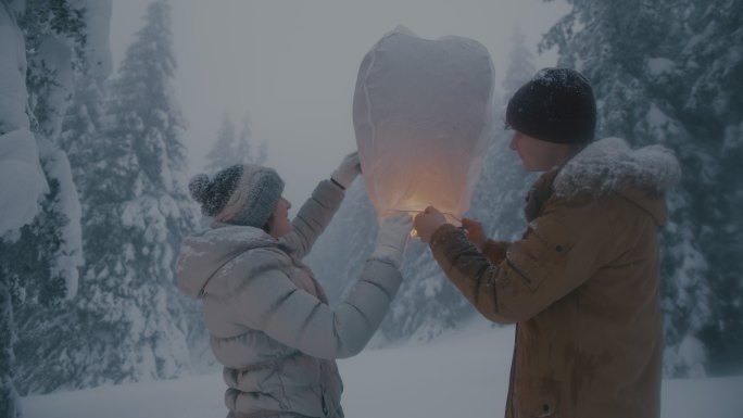 这对夫妇准备在雪地里放纸灯笼