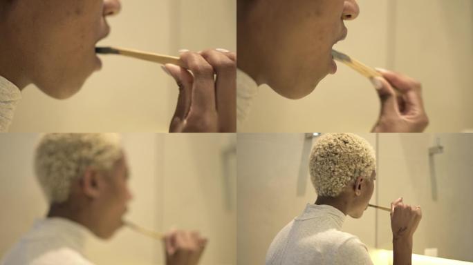 一位年轻的黑人妇女用竹刷和活性炭膏刷牙