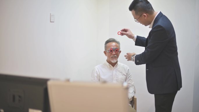 在眼科诊所检查视力的亚裔中国老年男性患者