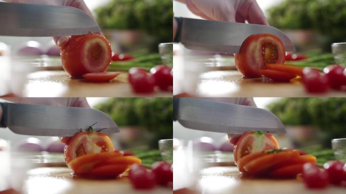 特写镜头：女性在烹饪板上用刀将新鲜的红色番茄切成薄片