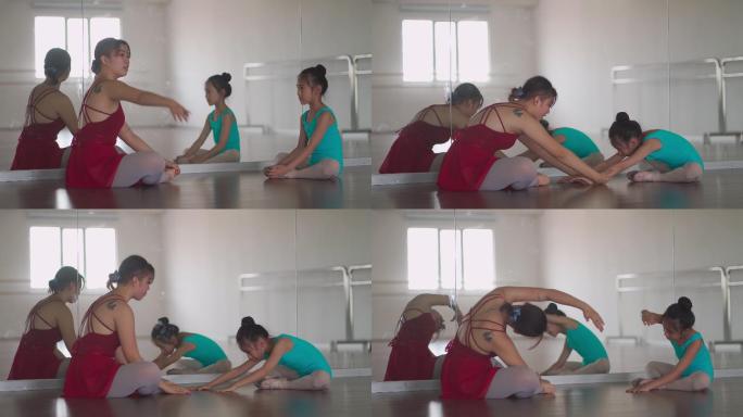 亚裔中国少女芭蕾舞演员在工作室里训练她的年轻女学生做热身运动