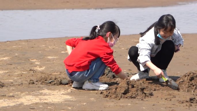 休闲娱乐小孩水边玩沙子沙滩卡通小黄鸭气球