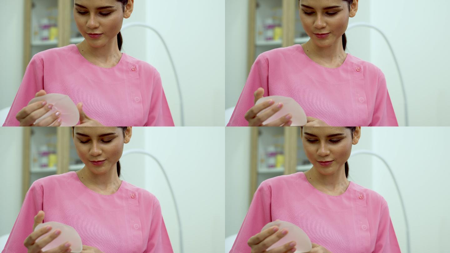 女患者在诊所展示硅胶乳房植入物。