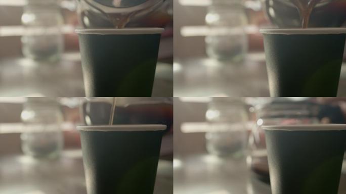 窗台上有一个咖啡壶，一个男人把咖啡倒进一个纸杯里