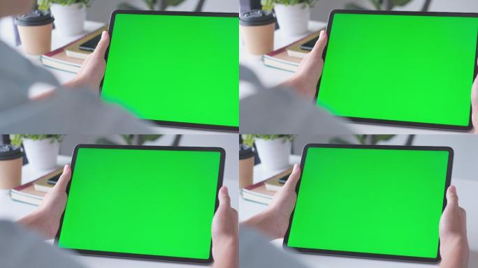 站在工作台上手持绿色屏幕的数字平板电脑模型的特写镜头