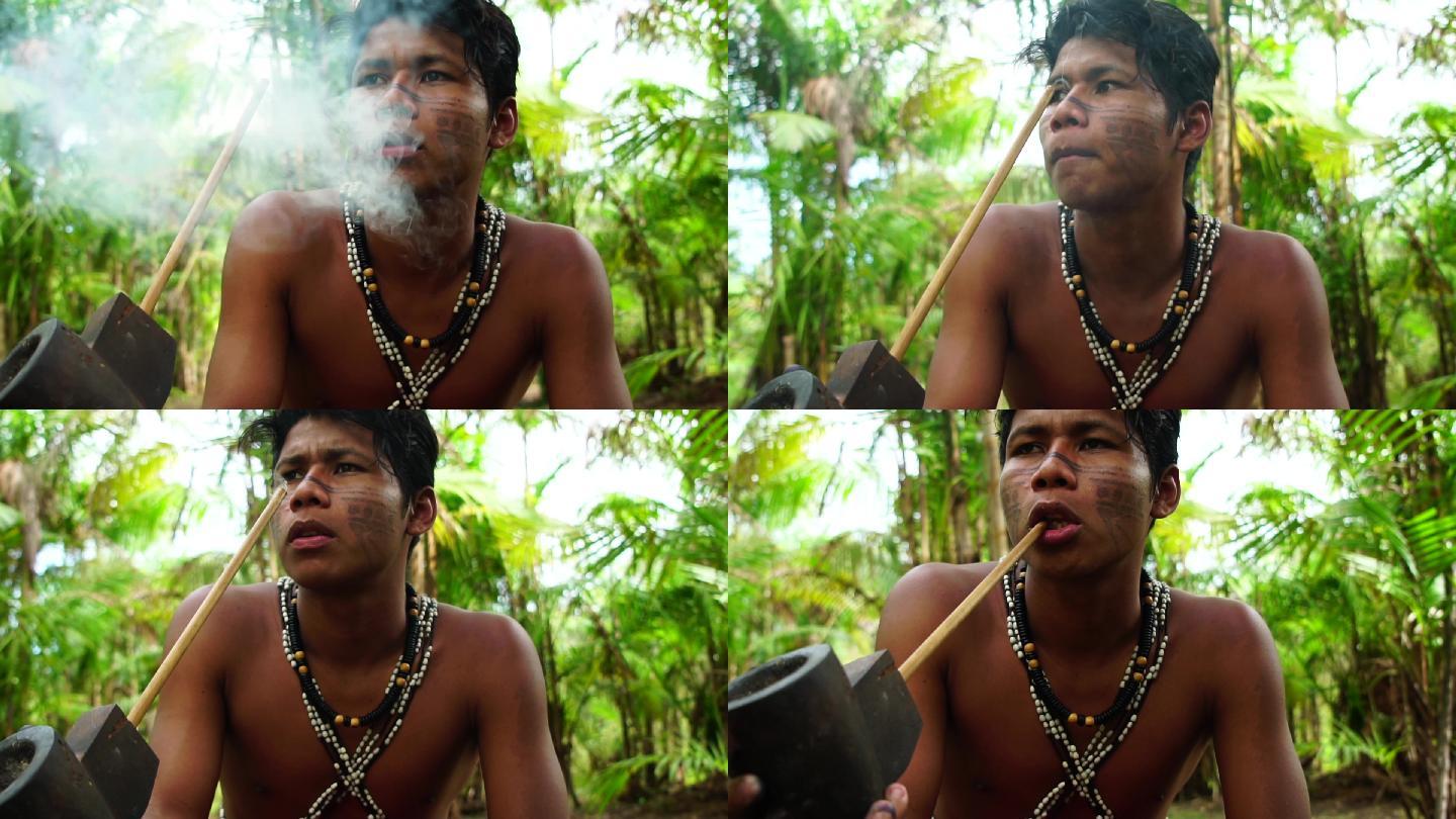 来自图皮瓜拉尼部落的土著男子在森林里抽烟斗，巴西