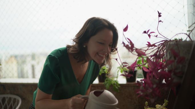 成熟的女人在阳台上浇花