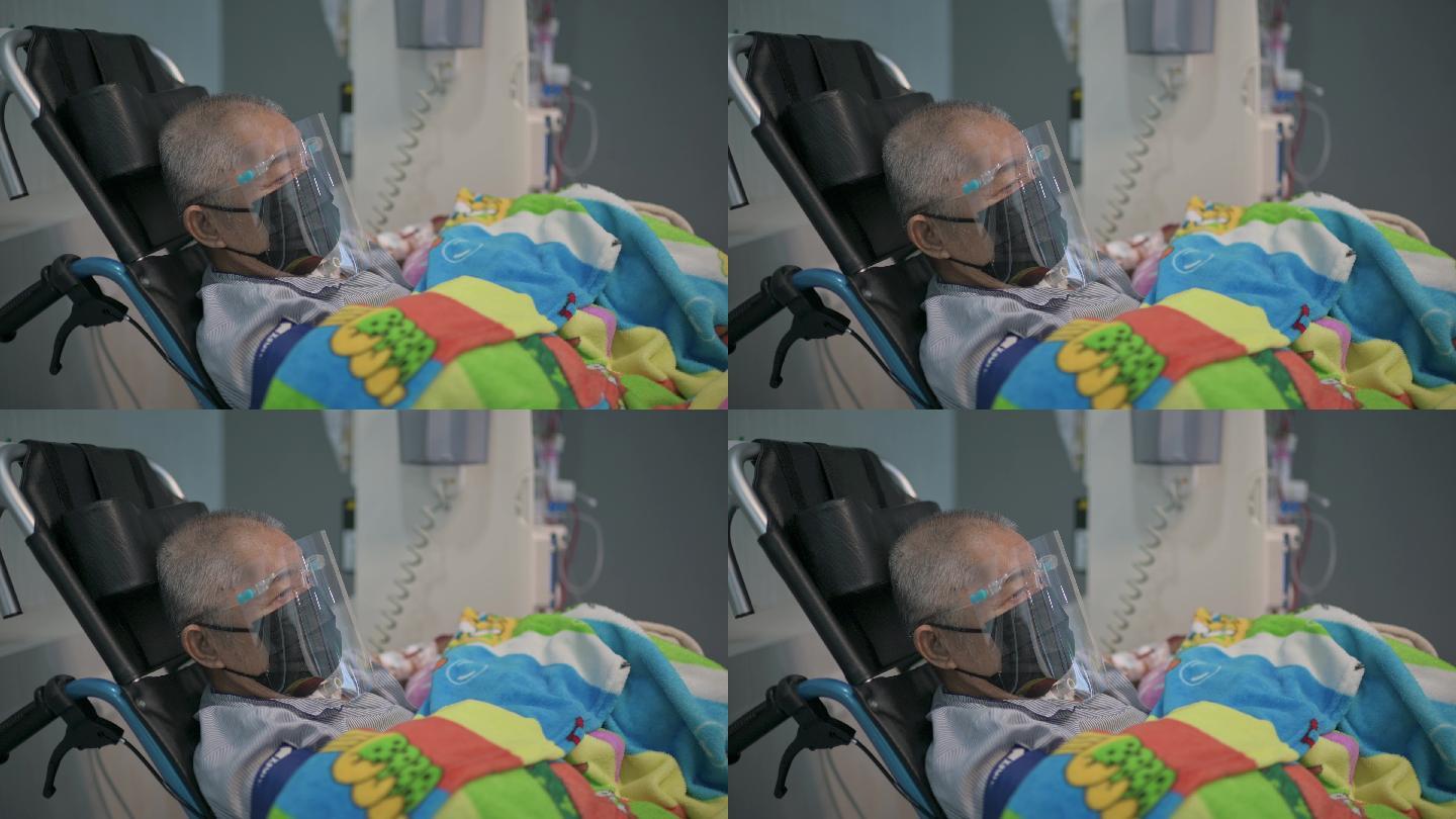 在医院接受透析治疗的亚裔中国老人，带着面罩，坐在轮椅上