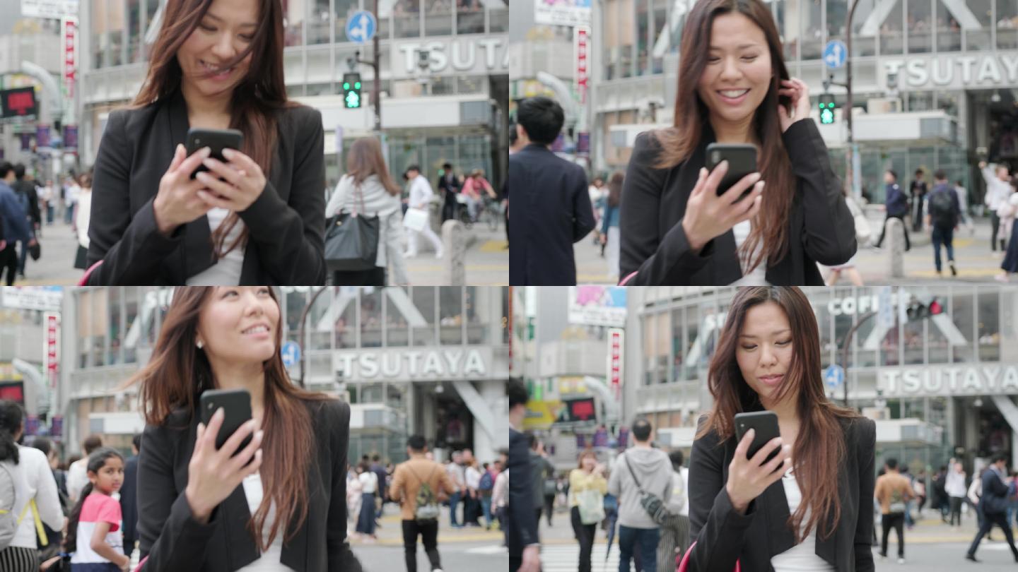日本东京街头，一位穿着西装、微笑着使用手机的快乐年轻亚洲女性