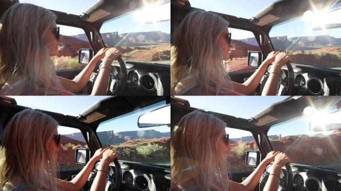 年轻女子在沙漠路上开车