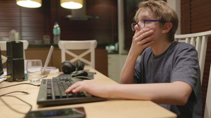 使用台式电脑玩多人在线游戏的十几岁男孩