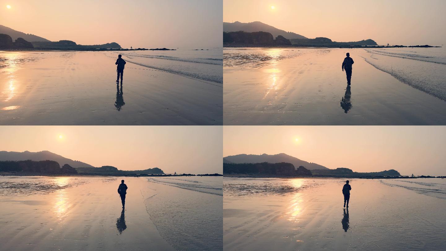 日出时在海滩上行走的人