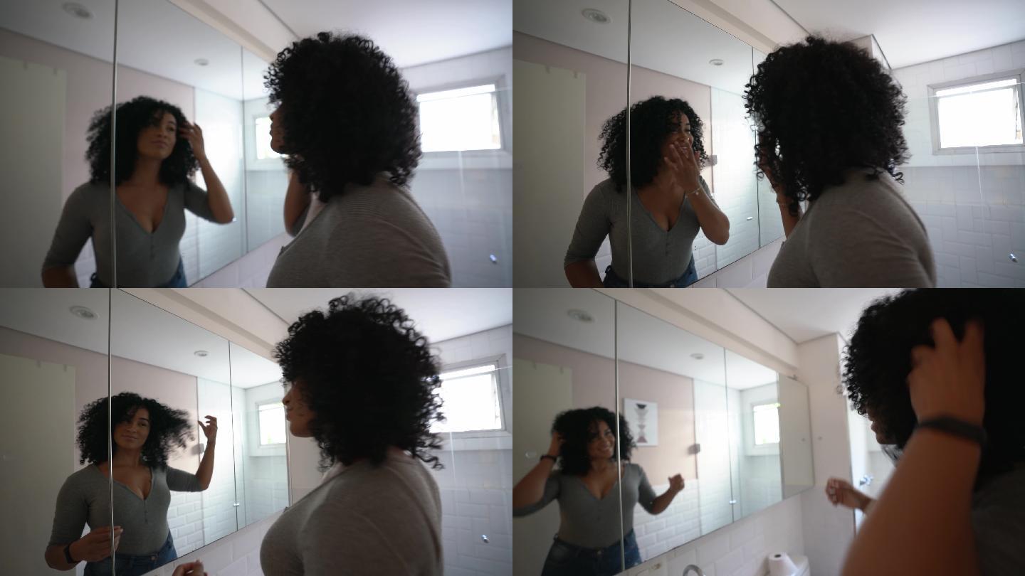年轻女子看着镜子整理头发