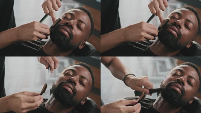 一段4k视频，一个英俊的年轻人坐在理发店，被理发师剃胡子