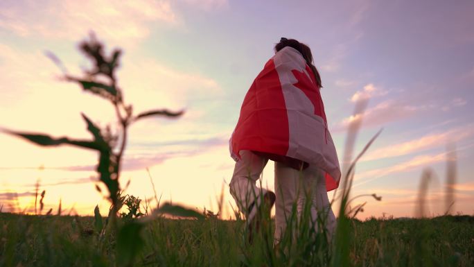 草地上，两名妇女用加拿大国旗遮住自己