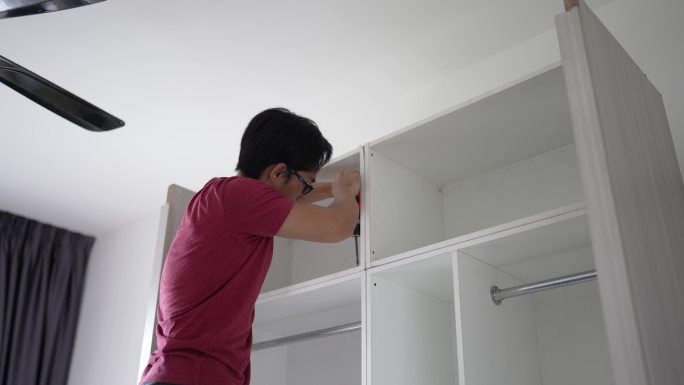 亚洲华人男子在家组装木柜