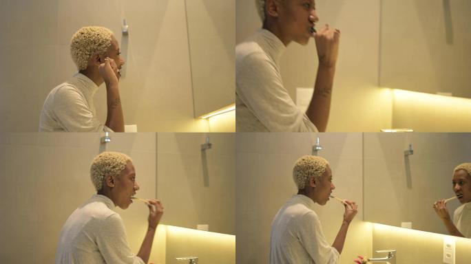 一位留着黄头发的年轻黑人妇女用活性炭膏刷牙。