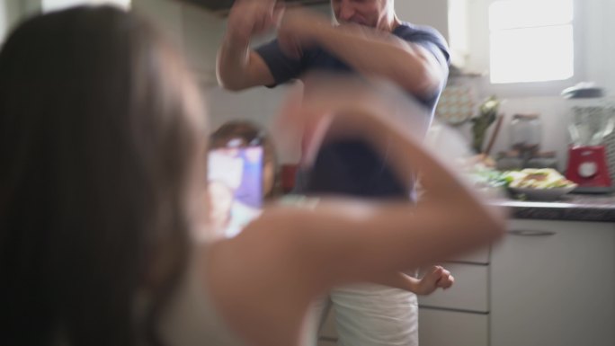 爸爸和女儿在厨房边跳舞边拍电影